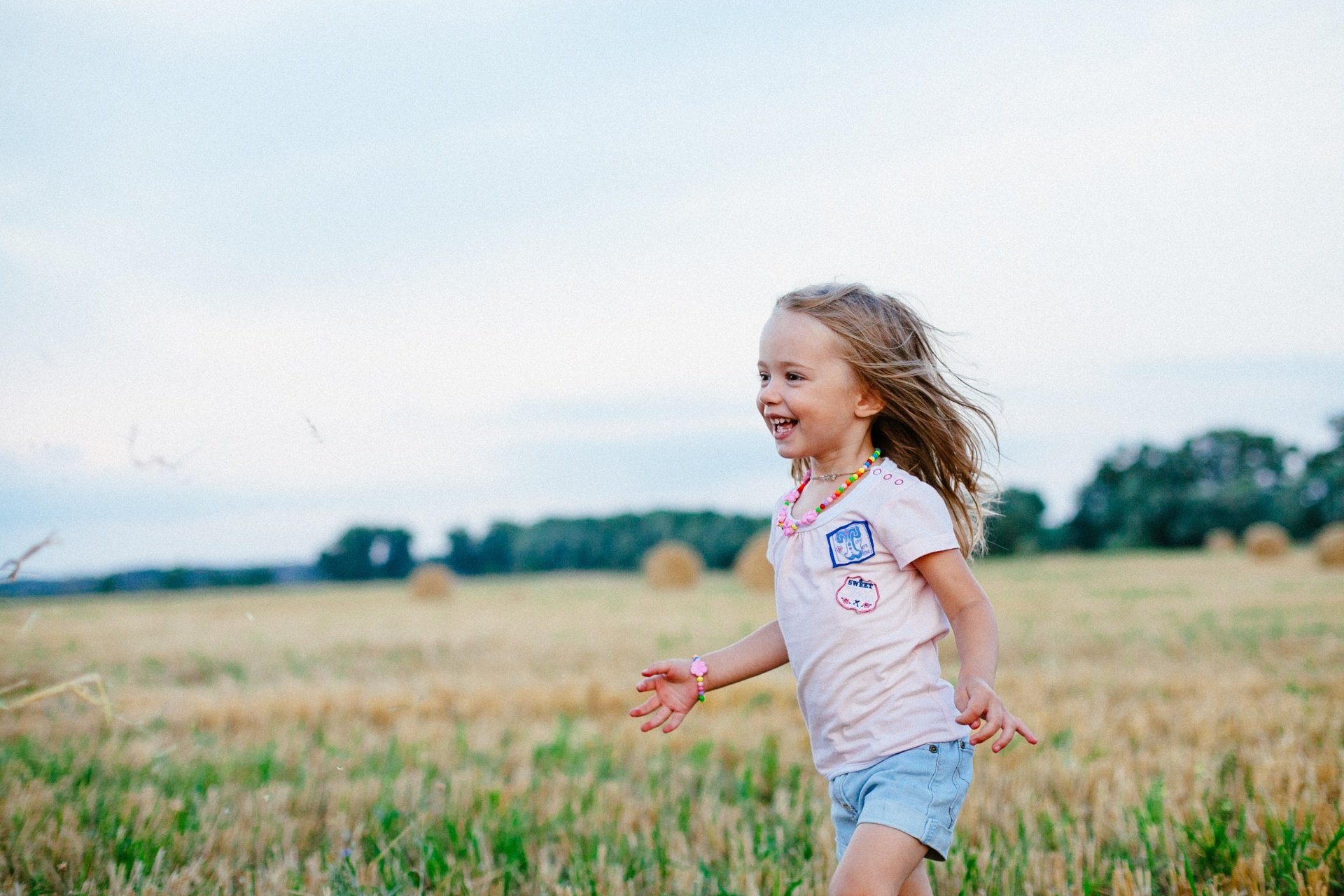 Smiling child running through a field