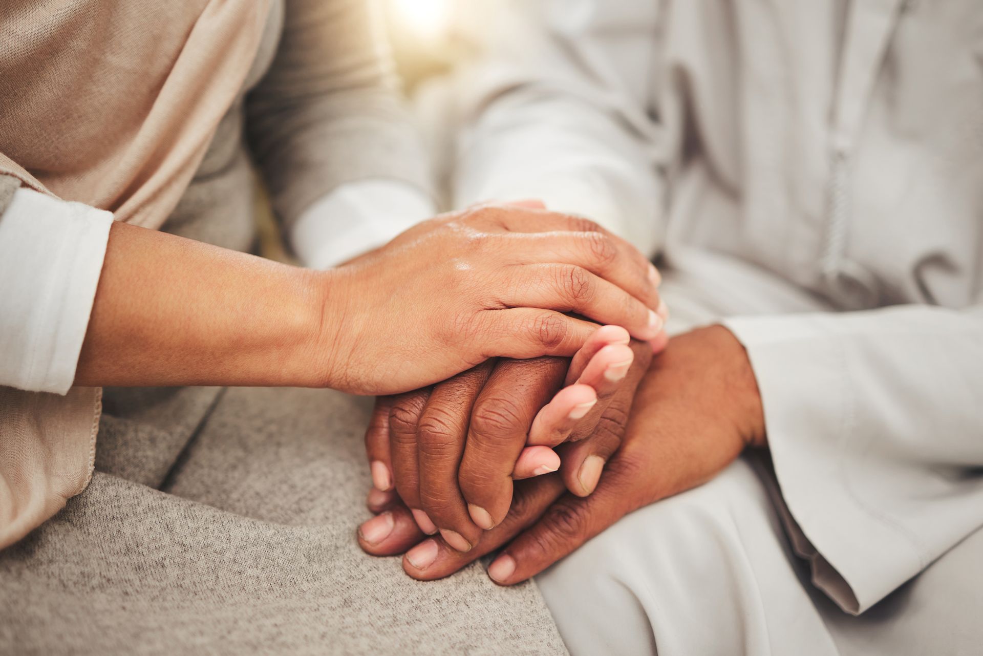 Two people holding hands in support